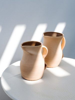 Different hand made custom-made ceramic pieces by Laura de Grinyo displayed on a wooden table