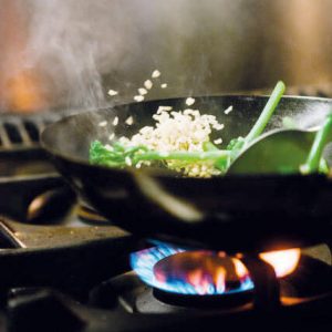 Preparation of a rice dish with fresh vegetables over an open fire